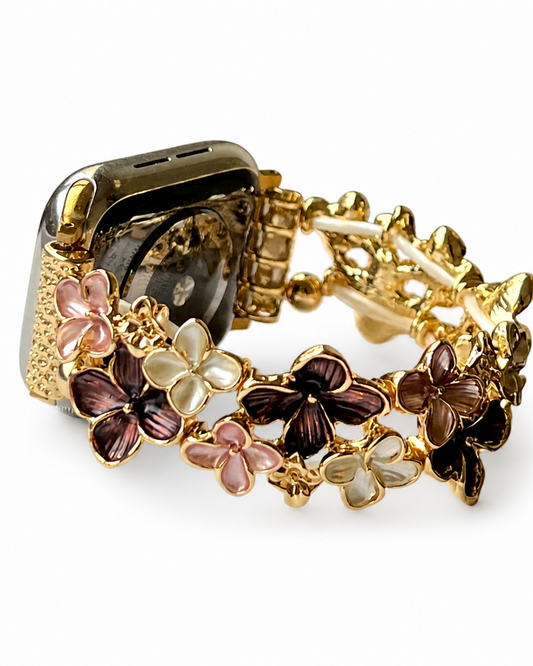 Gold-tone smartwatch band decorated with brown, pink, and cream flower charms.
